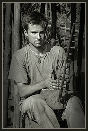 Luis Devin with an arched harp in a rainforest camp of the Baka Pygmies